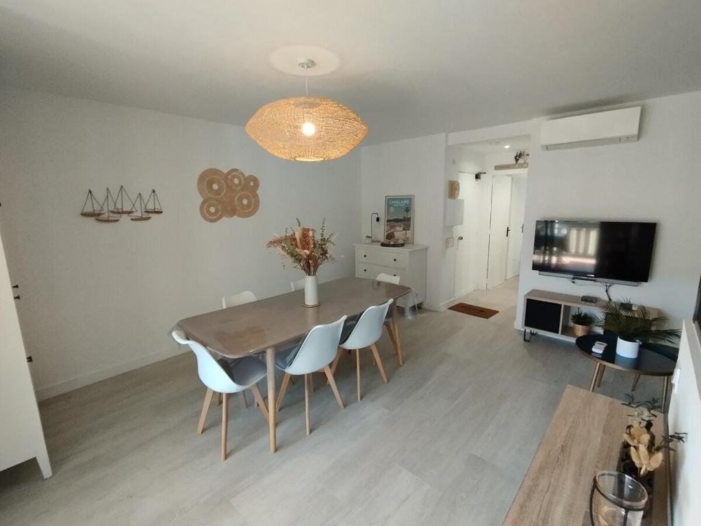 une salle à manger avec une table, des chaises et une télévision dans l'établissement Central, terrasse, proche plage et toute proximité, à Cavalaire-sur-Mer