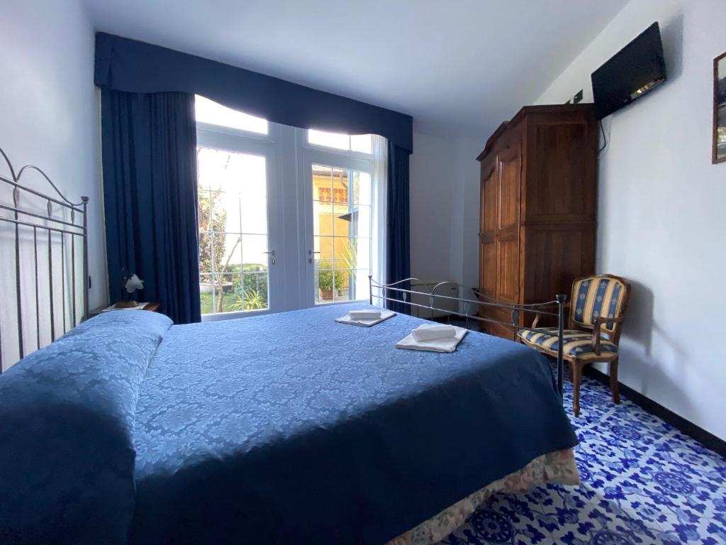 a bedroom with a blue bed and a window at Villa Margherita in Levanto