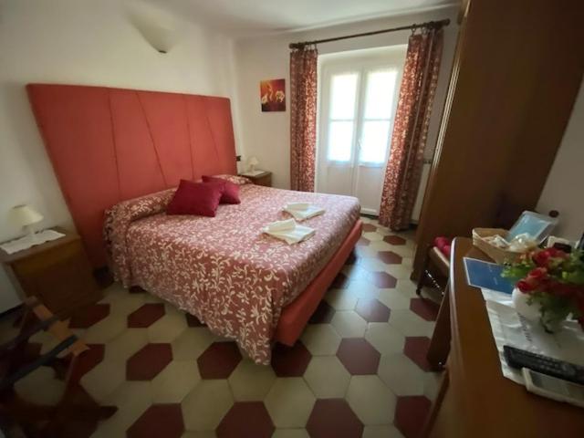 a bedroom with a bed with a red headboard at Villa Margherita in Levanto