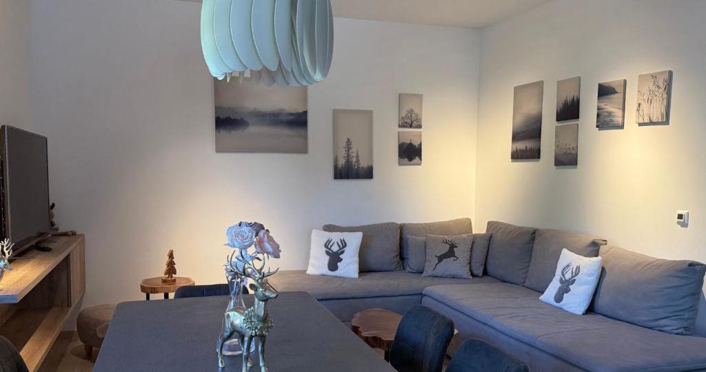 a living room with a blue couch and a table at Vila Mojca SKI IN&OUT - Apartmaji Lena in Kranjska Gora