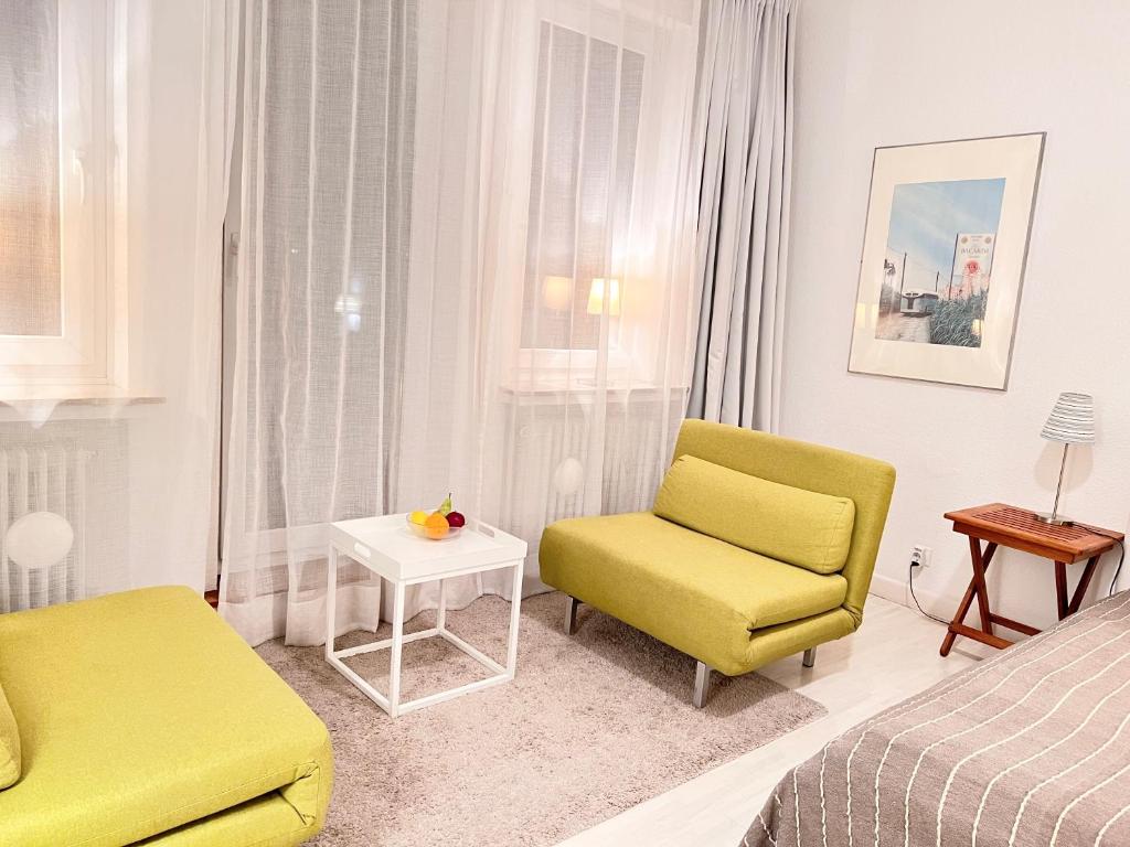 ブレーメンにあるBremen City Apartmentのベッドと椅子とテーブルのある寝室