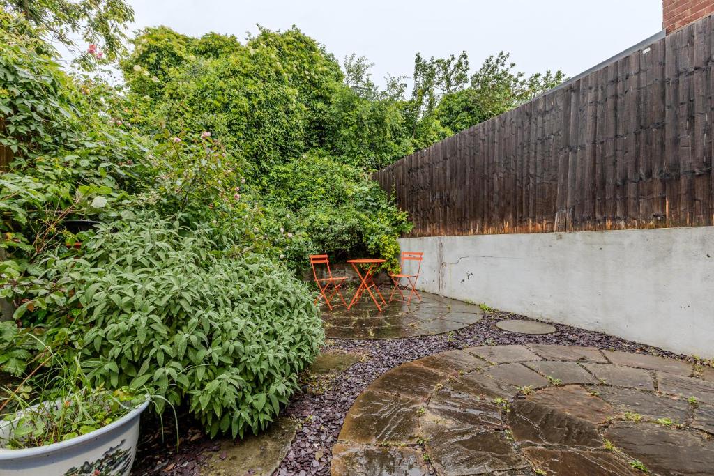 a patio with a table and a fence at Gorgeous 2BR plus Victorian home with Parking and Garden in London