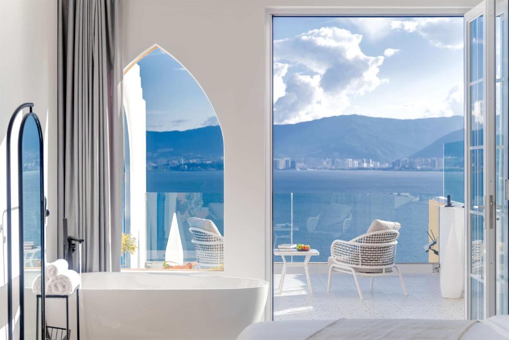 a bathroom with a tub and a view of the water at Dandi Seaview Resort Villas, Dali in Dali
