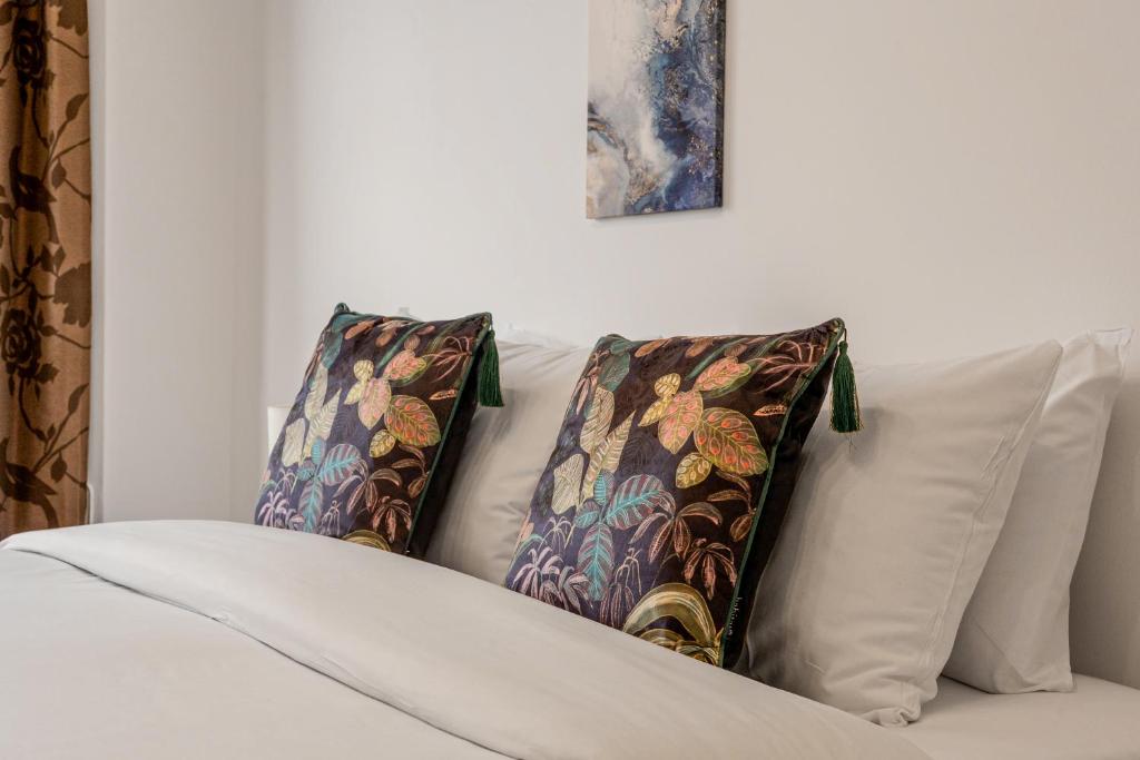 a white couch with two pillows on it at Gorgeous 2BR plus Victorian home with Parking and Garden in London