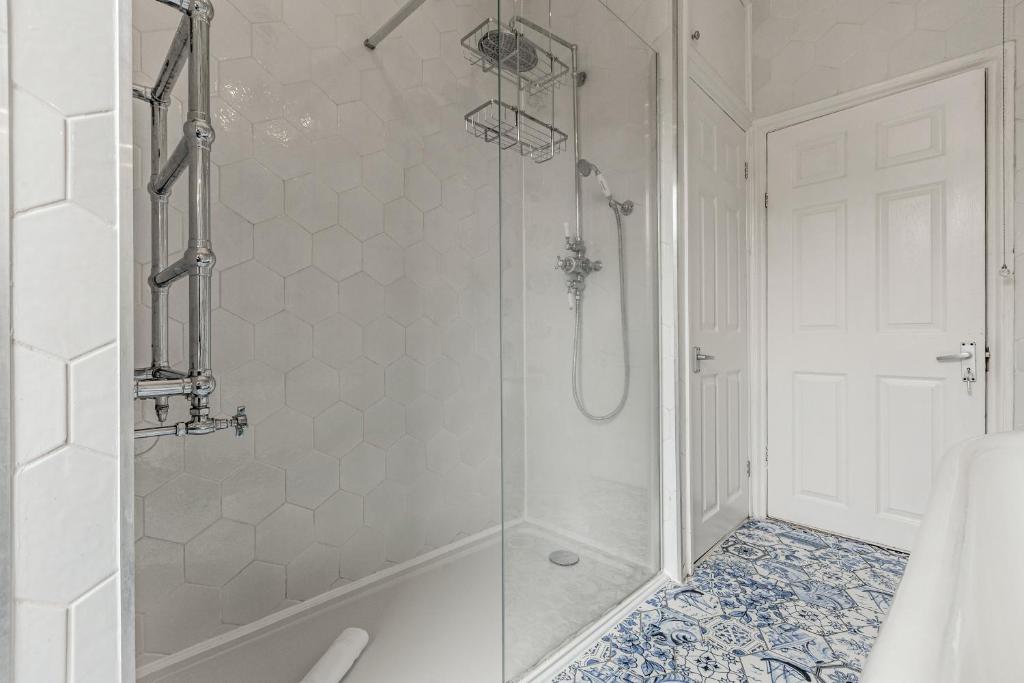 a shower with a glass door in a bathroom at Gorgeous 2BR plus Victorian home with Parking and Garden in London