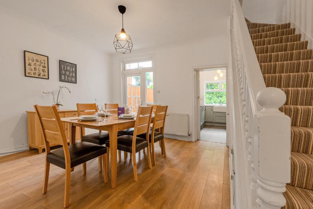 a dining room with a wooden table and chairs at Gorgeous 2BR plus Victorian home with Parking and Garden in London