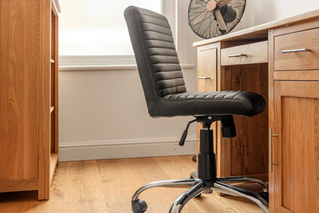 a black office chair sitting next to a desk at Gorgeous 2BR plus Victorian home with Parking and Garden in London