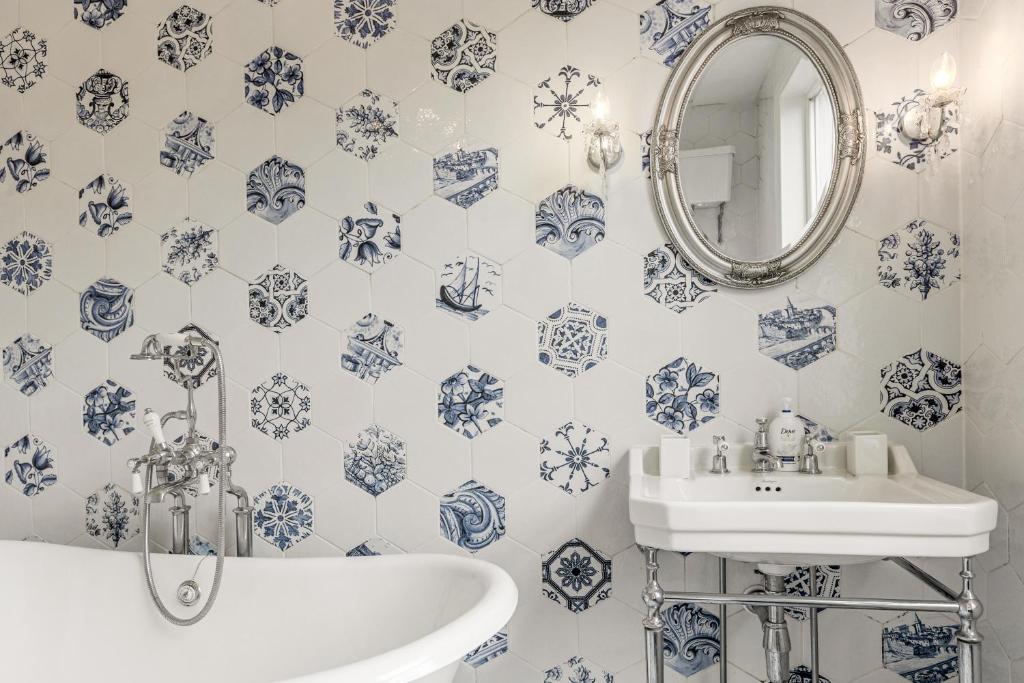 a blue and white bathroom with a sink and a mirror at Gorgeous 2BR plus Victorian home with Parking and Garden in London