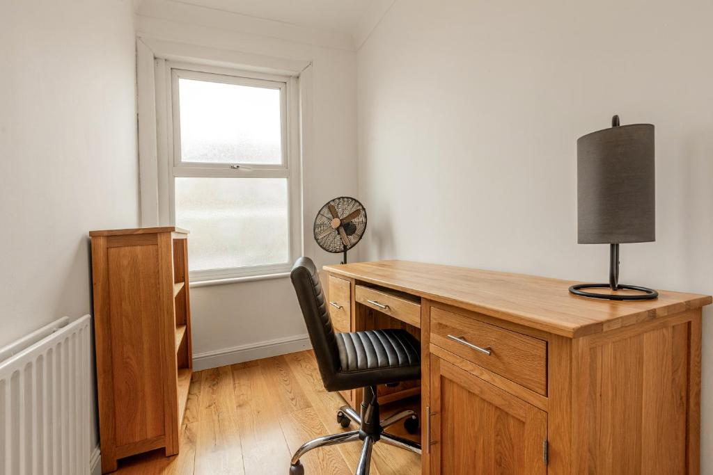 a desk with a chair in a room with a window at Gorgeous 2BR plus Victorian home with Parking and Garden in London