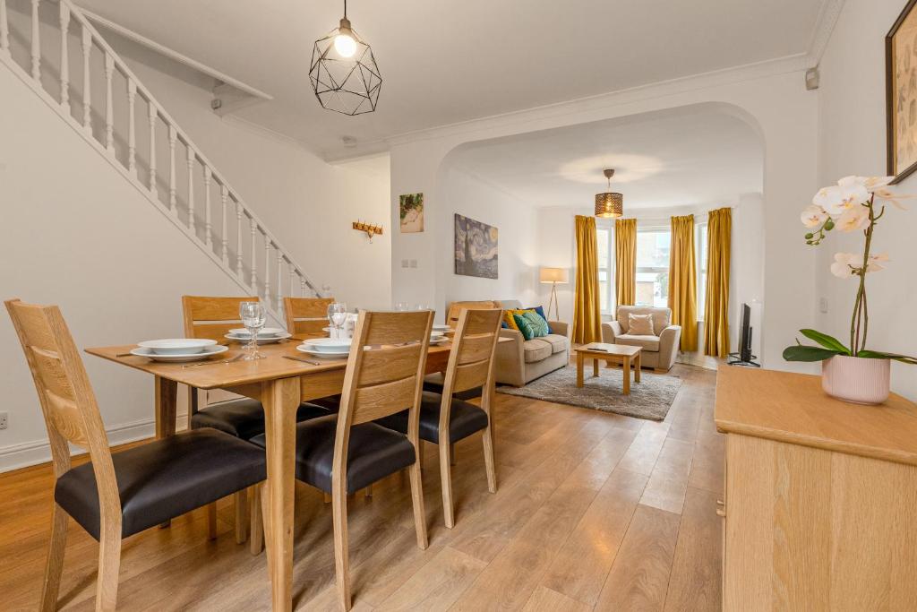 a dining room and living room with a table and chairs at Gorgeous 2BR plus Victorian home with Parking and Garden in London