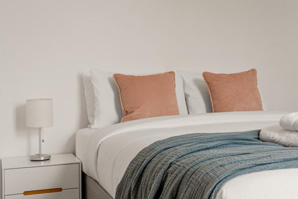a bedroom with a white bed with pillows and a nightstand at Gorgeous 2BR plus Victorian home with Parking and Garden in London