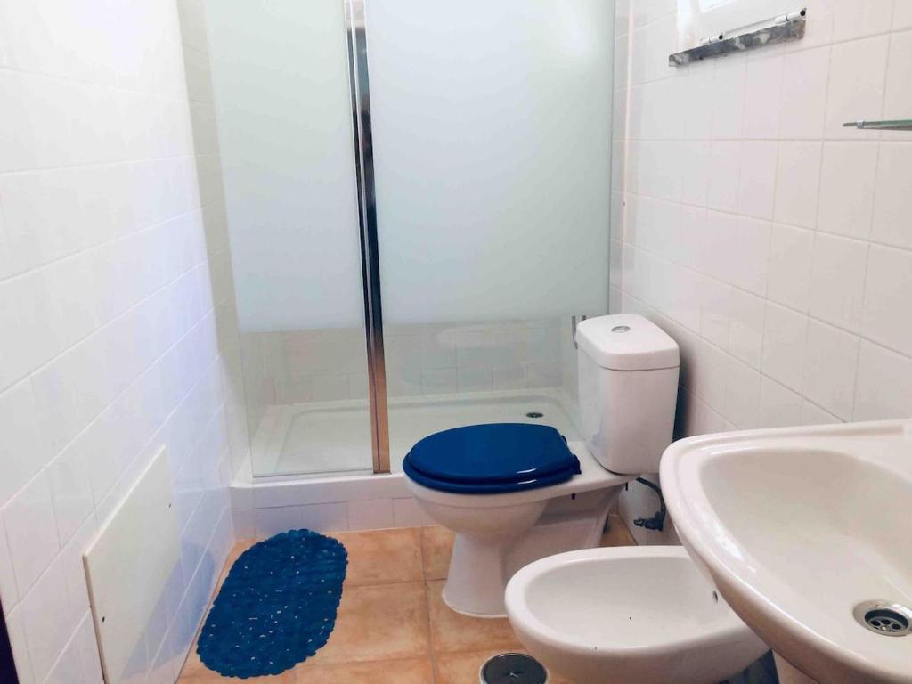 Un baño con ducha, inodoro y lavabo. en Paderne Village House, en Paderne