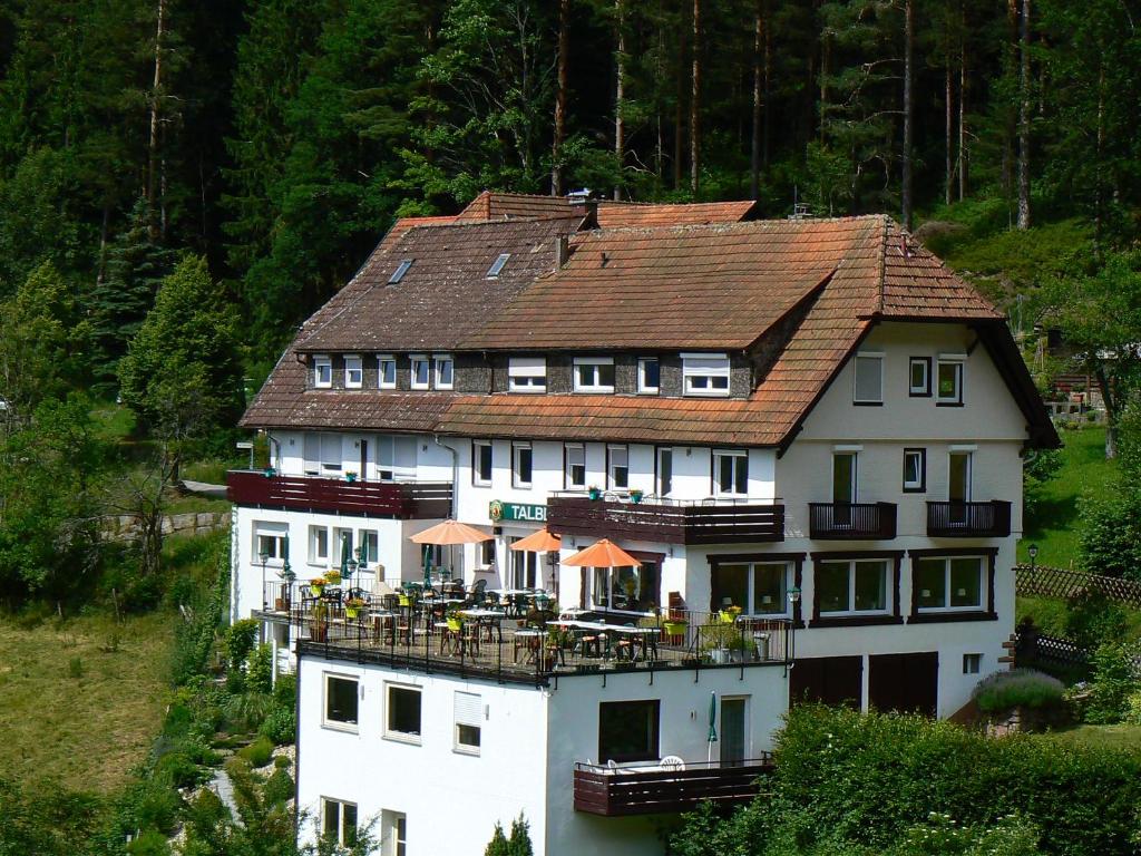 ein großes weißes Gebäude mit einem braunen Dach in der Unterkunft Gasthaus Talblick - Schwarzwald Plus Karte inkludiert in Baiersbronn
