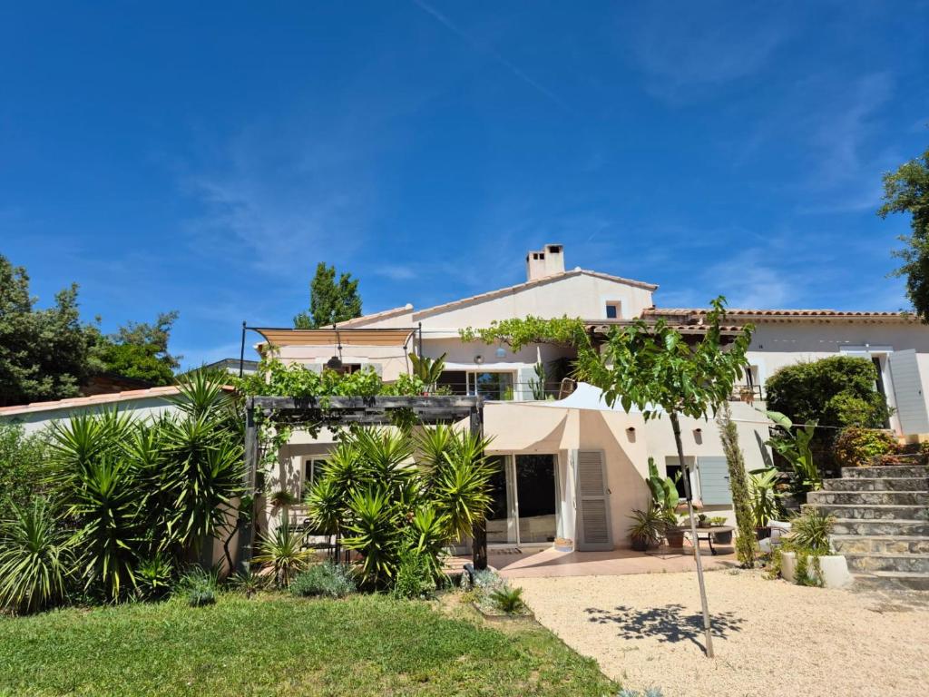 une maison blanche avec des palmiers dans la cour dans l'établissement Le Repaire de la Cadière à 5mn des plages !, à Saint-Cyr-sur-Mer