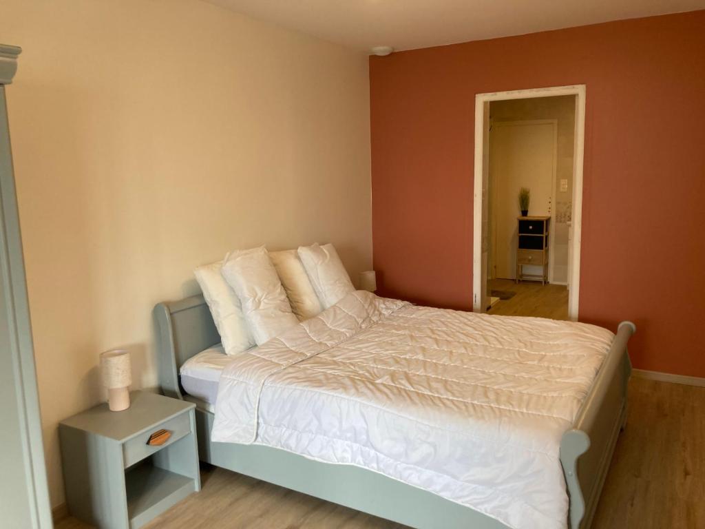 une chambre avec un lit avec des draps blancs et des oreillers dans l'établissement Gîte avec spa et piscine près de Millau, à Compeyre