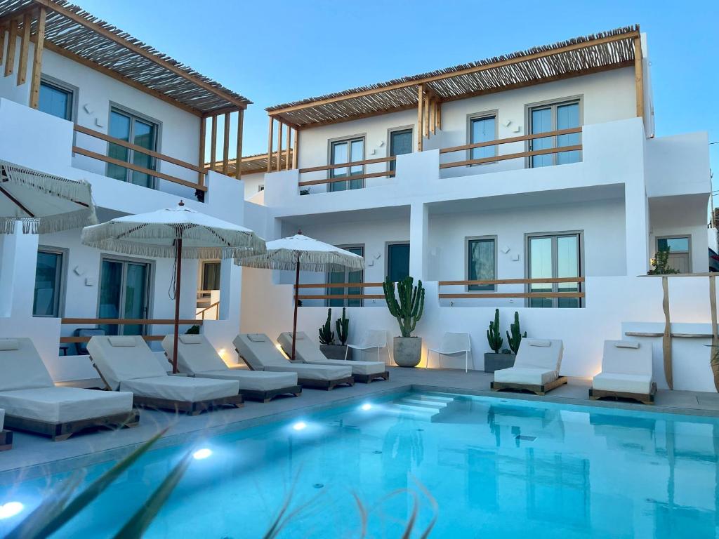 a villa with a swimming pool in front of a building at Mykonos Dot Suites in Ano Mera