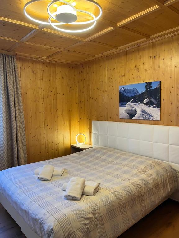 a bedroom with a bed with two pillows on it at Sappada Family Apartments in Sappada