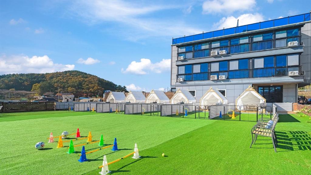a large building with a field with cones on it at Namhae Dangdangi Dog Pension Blue in Namhae