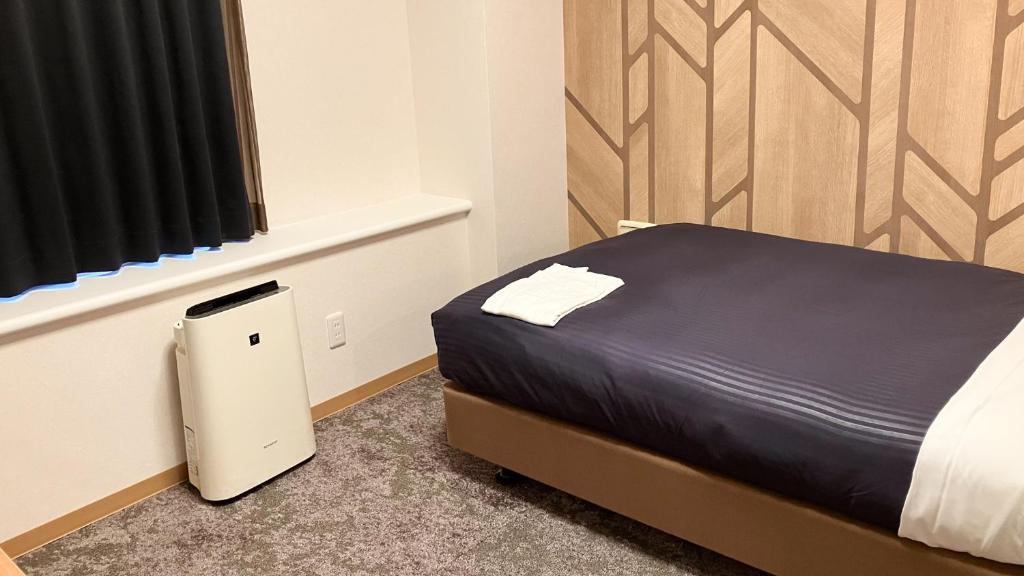 Postel nebo postele na pokoji v ubytování HOTEL LiVEMAX BUDGET Shinbashi