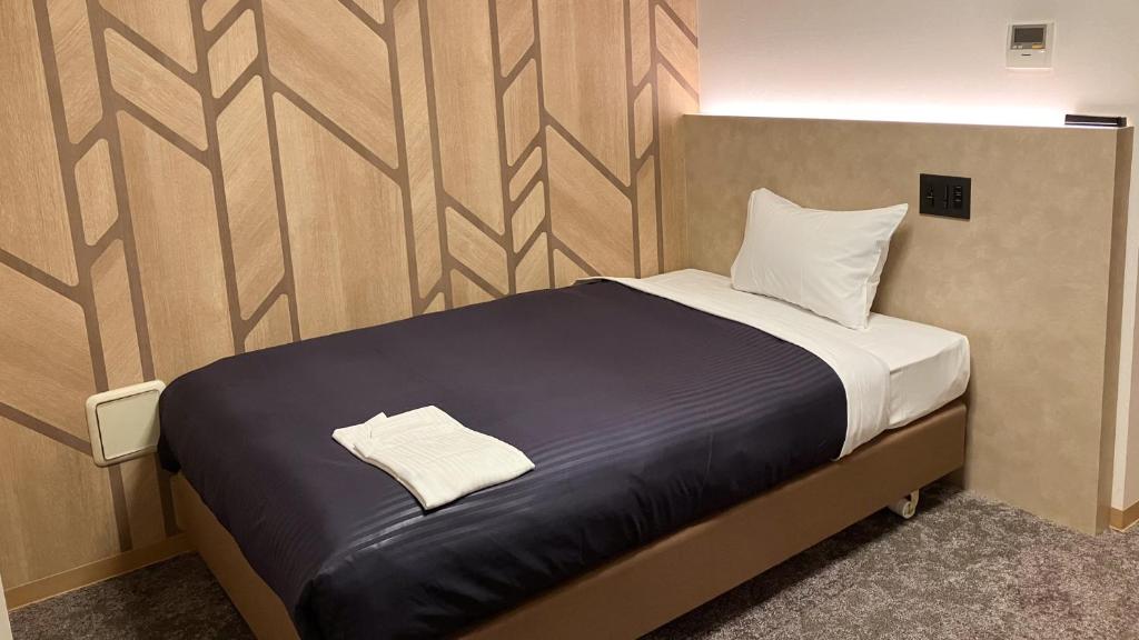 Postel nebo postele na pokoji v ubytování HOTEL LiVEMAX BUDGET Shinbashi