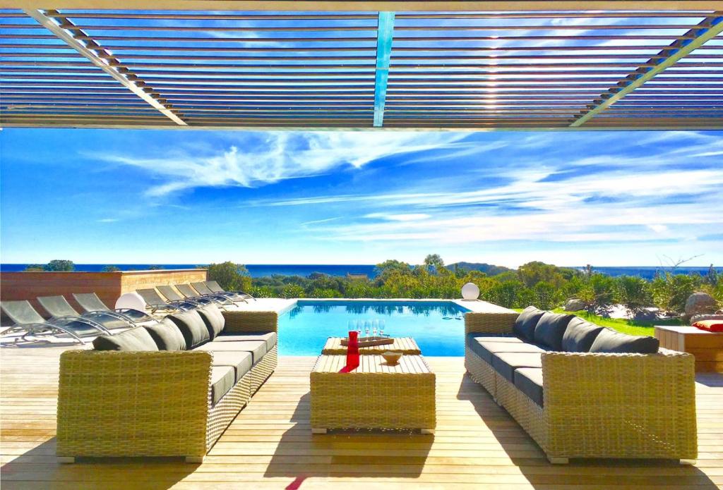 - une piscine avec des chaises longues et une table dans l'établissement Piscine chauffée, villa vue mer, proche Pinarello, à Zonza