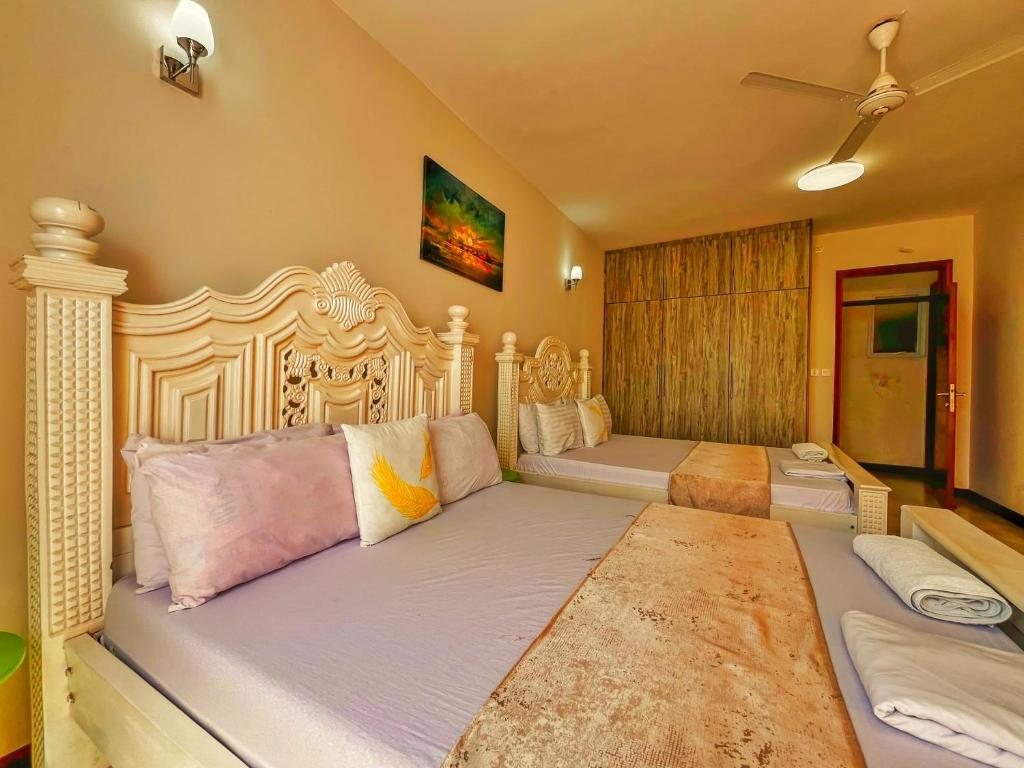 a large bedroom with two beds and a fan at Nyali Luxury Apartments, Antalya in Mombasa