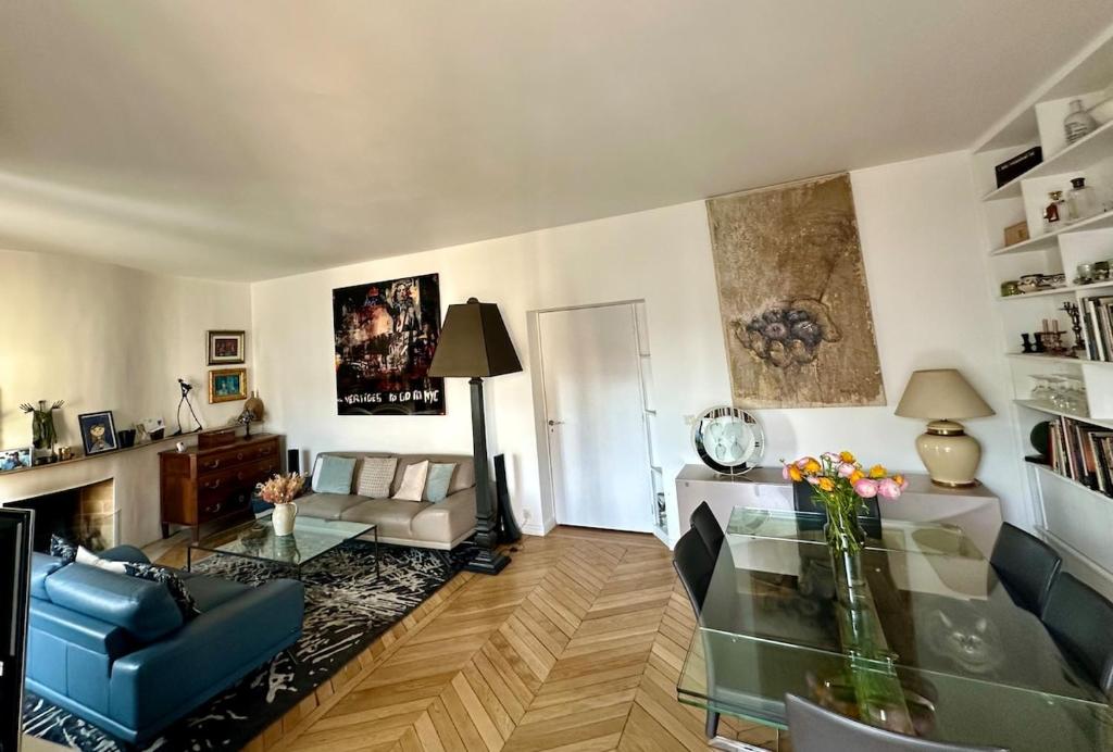 un salon avec un canapé et une table en verre dans l'établissement Beautiful Apartment with Seine and Musée d'Orsay View, à Paris