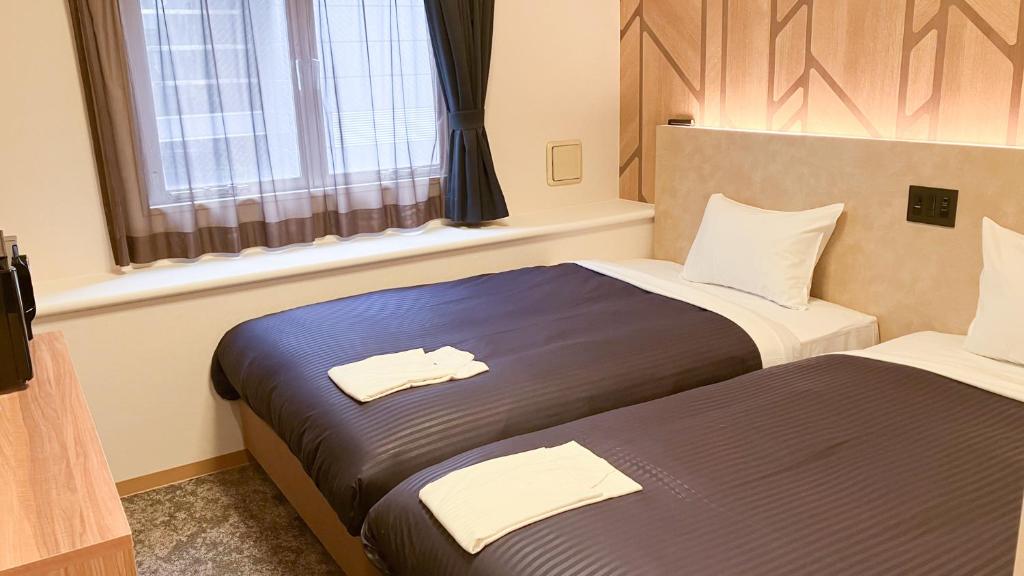 Postel nebo postele na pokoji v ubytování HOTEL LiVEMAX BUDGET Shinbashi