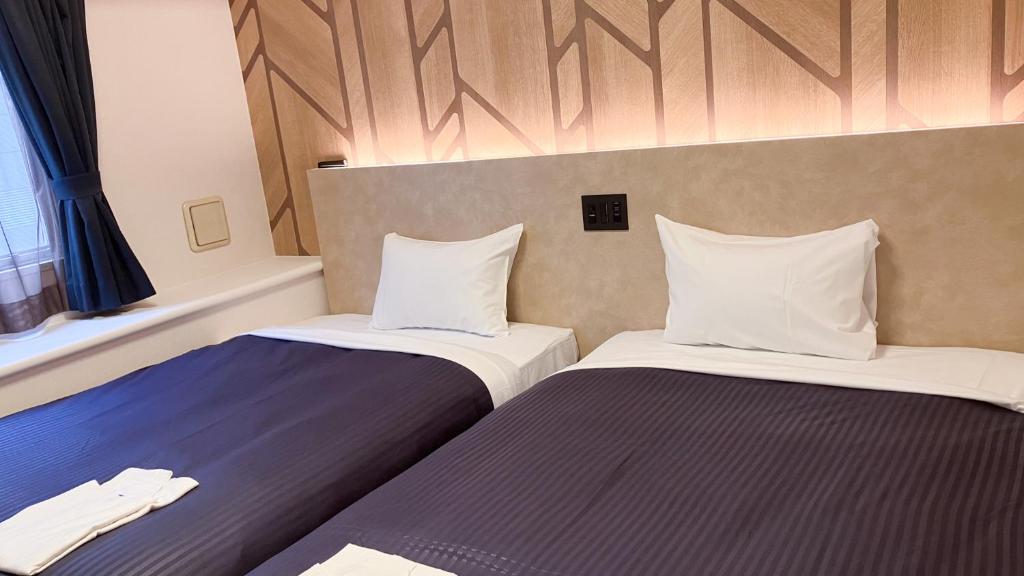 Postel nebo postele na pokoji v ubytování HOTEL LiVEMAX BUDGET Shinbashi