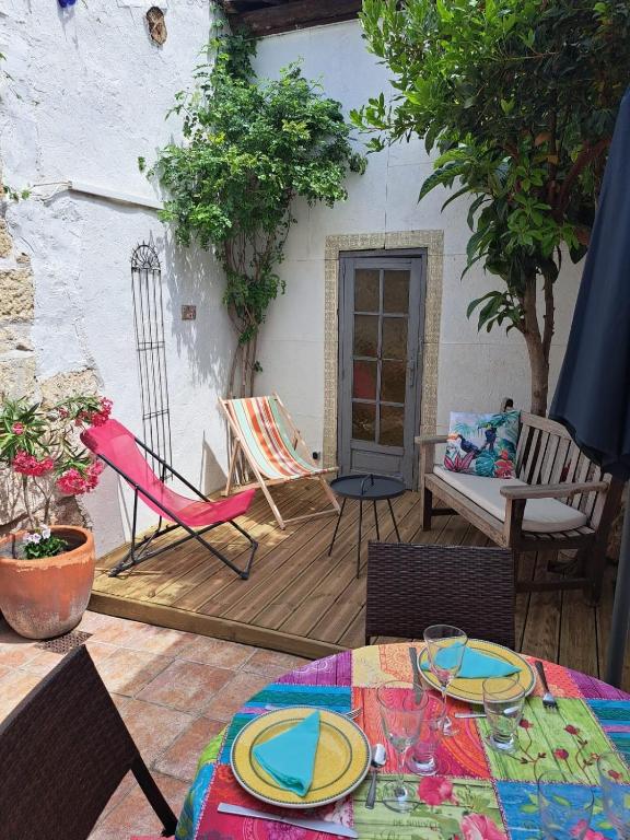 d'une terrasse avec des chaises et une table. dans l'établissement Maison typique intra-muros, à Aigues-Mortes