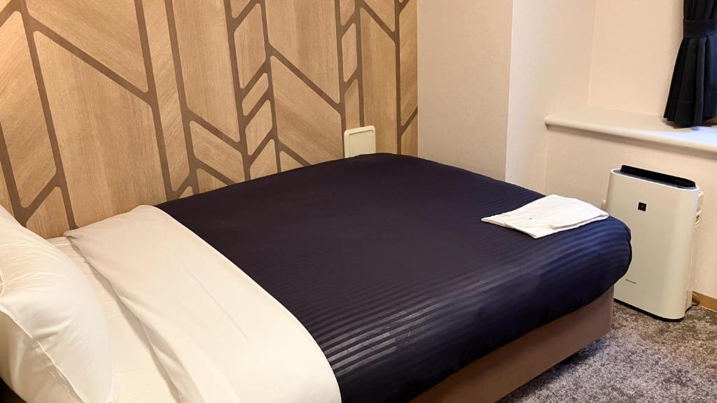 Postel nebo postele na pokoji v ubytování HOTEL LiVEMAX BUDGET Shinbashi