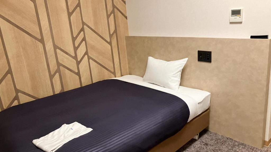 Postel nebo postele na pokoji v ubytování HOTEL LiVEMAX BUDGET Shinbashi
