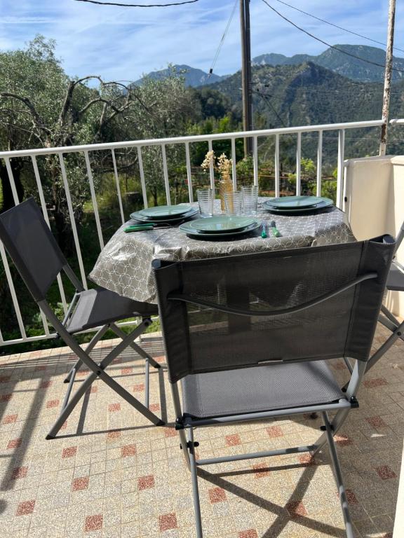 d'une table et de chaises sur un balcon avec une table et des assiettes. dans l'établissement La place du Four Communal, à Breil-sur-Roya