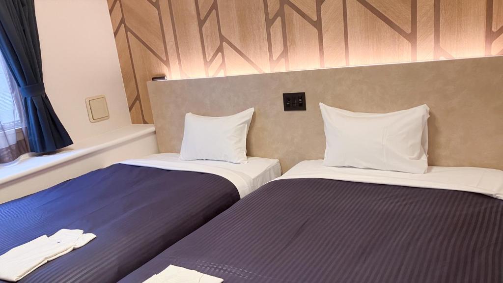 Postel nebo postele na pokoji v ubytování HOTEL LiVEMAX BUDGET Shinbashi