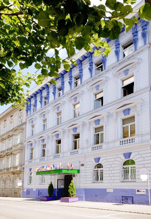 a white building with blue trim at Westend City Hostel in Vienna