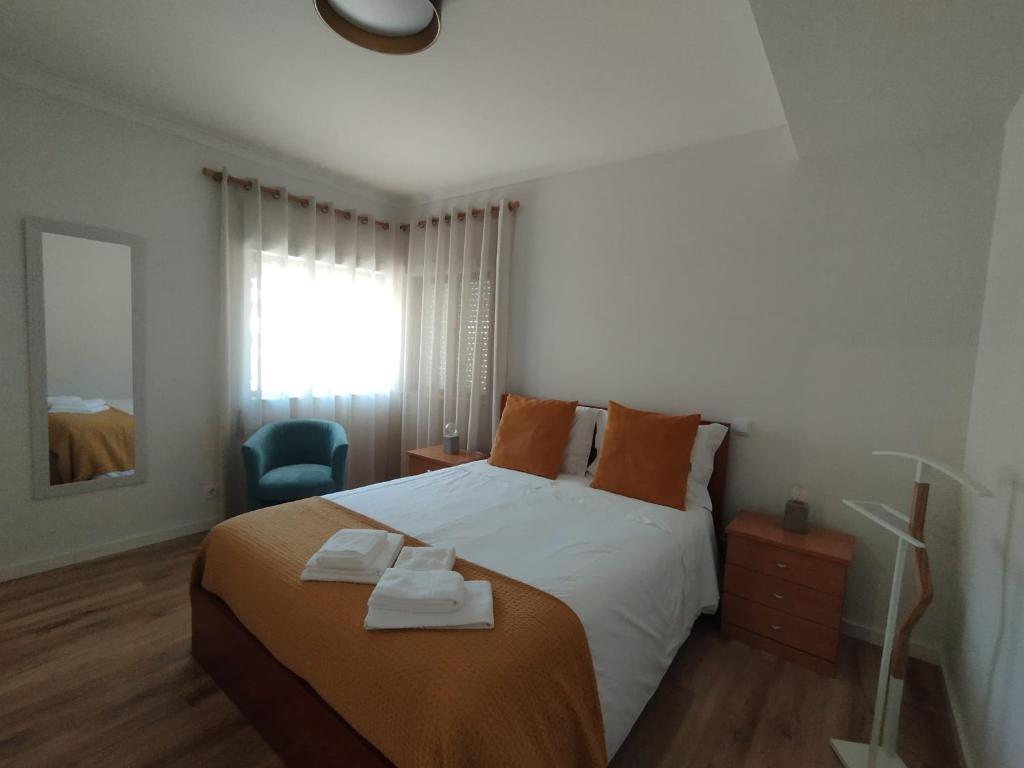 a bedroom with a large bed and a blue chair at Casa da TITA in Vila Praia de Âncora