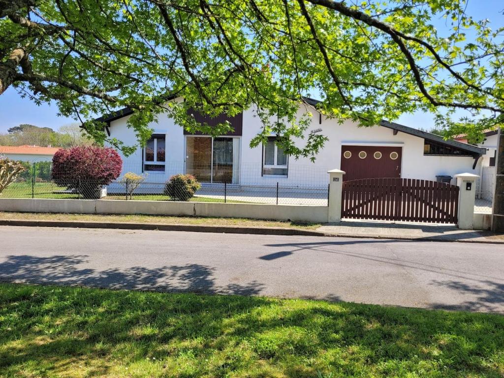 une maison blanche avec une clôture devant dans l'établissement Charmante villa près du centre de Bayonne et des plages, à Boucau