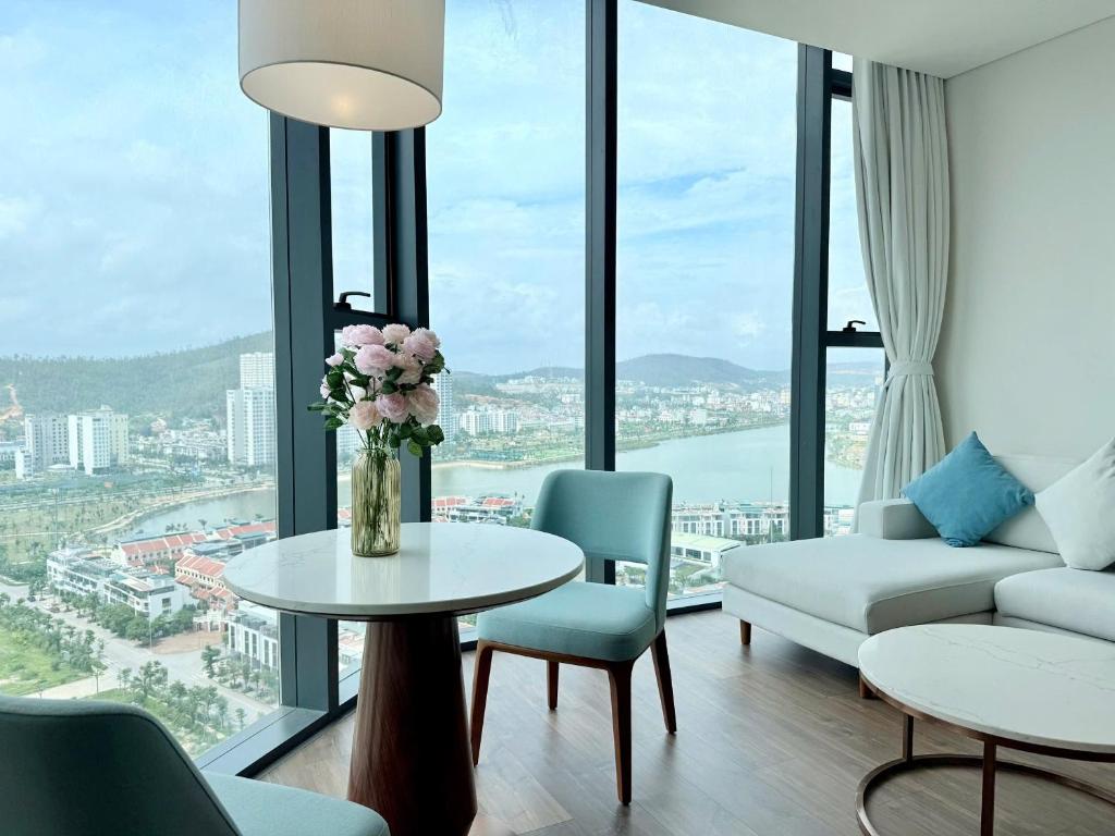a living room with a table with a vase of flowers at Spring ALacarte Ha Long Luxury Studio in Ha Long