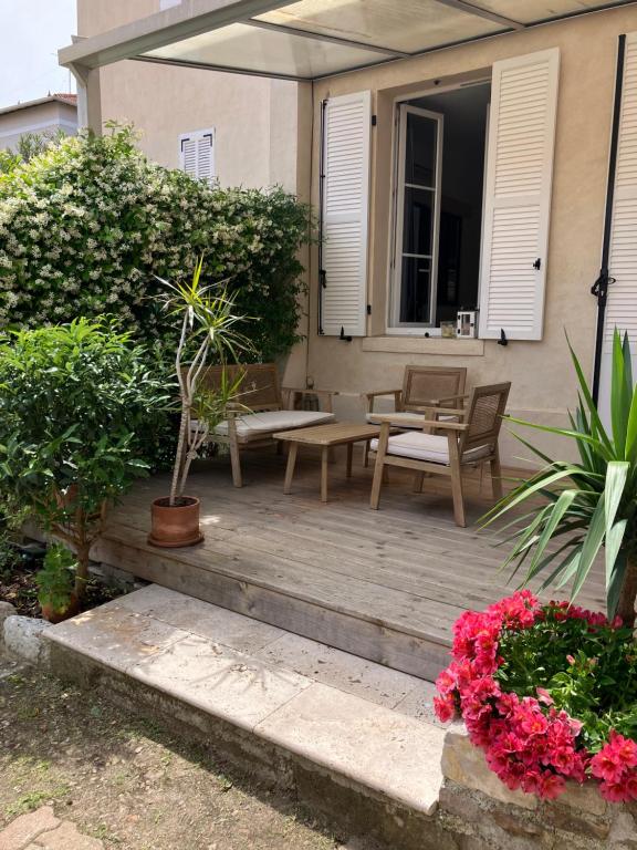 - une terrasse avec une table, des chaises et des fleurs dans l'établissement Charmant appartement cosy, à Saint-Raphaël