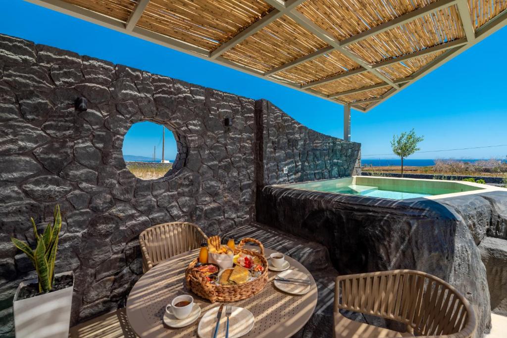 a table with a basket of food on a patio at Mperes Villas in Santorini