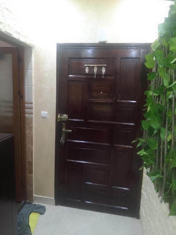 a wooden door in a room with a plant at Appartement aissa in Oulad Akkou