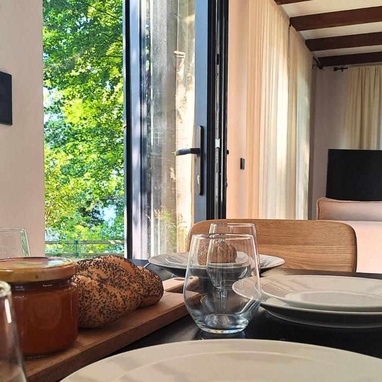 a table with plates and glasses and a window at Zakontek Lubkowa in Lubkowo