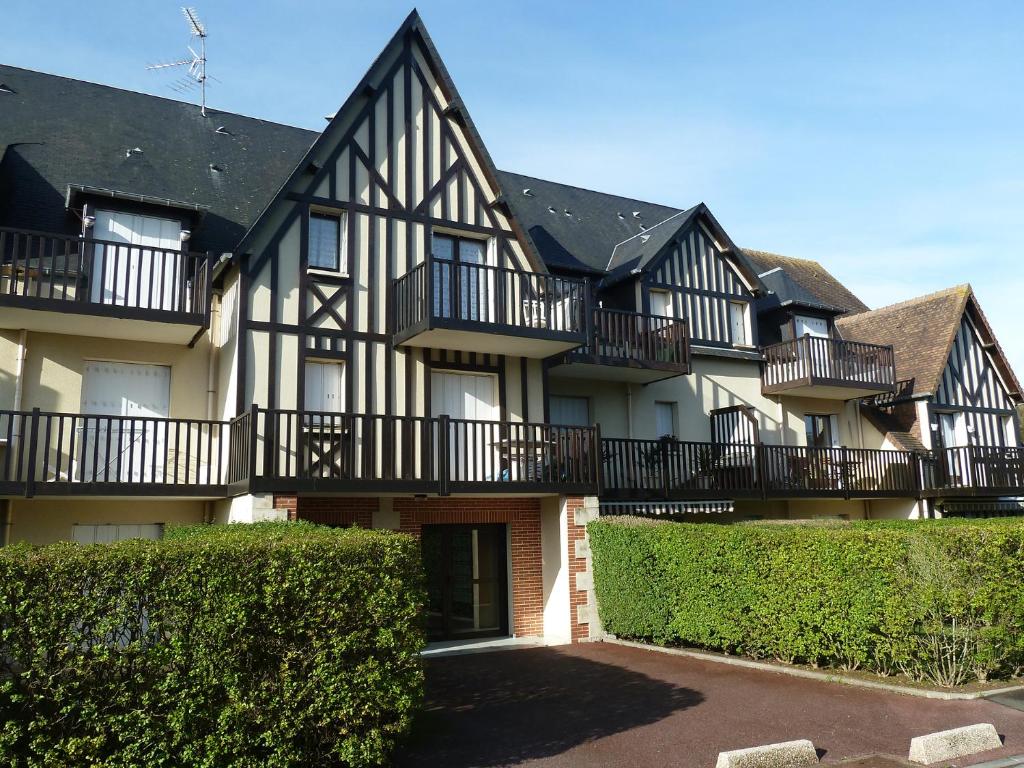 un grand bâtiment avec des balcons sur le côté dans l'établissement Acces direct à la mer proche thalasso, à Cabourg