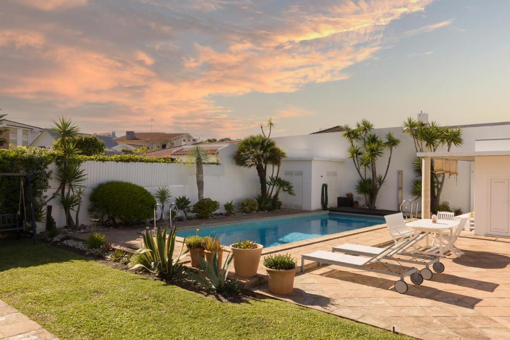 a backyard with a swimming pool and a house at Moradia exclusiva junto ao mar in Gafanha da Nazaré