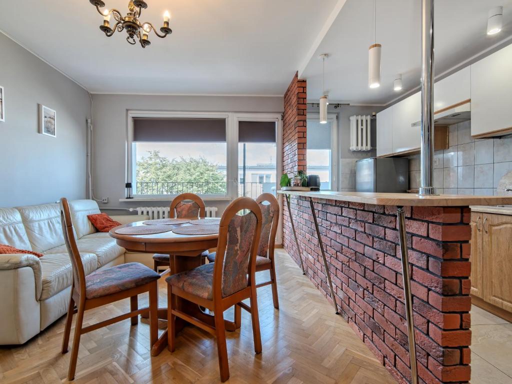 a kitchen and living room with a table and chairs at Platinium Wrzeszcz - Batorego in Gdańsk
