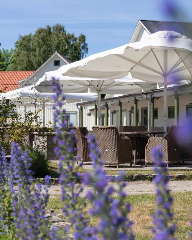 a group of chairs and umbrellas in front of a house at Toftagården Bed and Breakfast in Gnisvärd