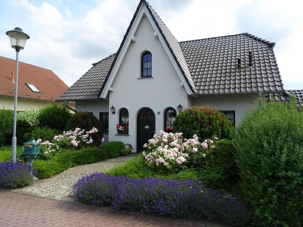 a white house with flowers in front of it at Schönes Ferienhaus in Radewege mit schönem Garten in Radewege