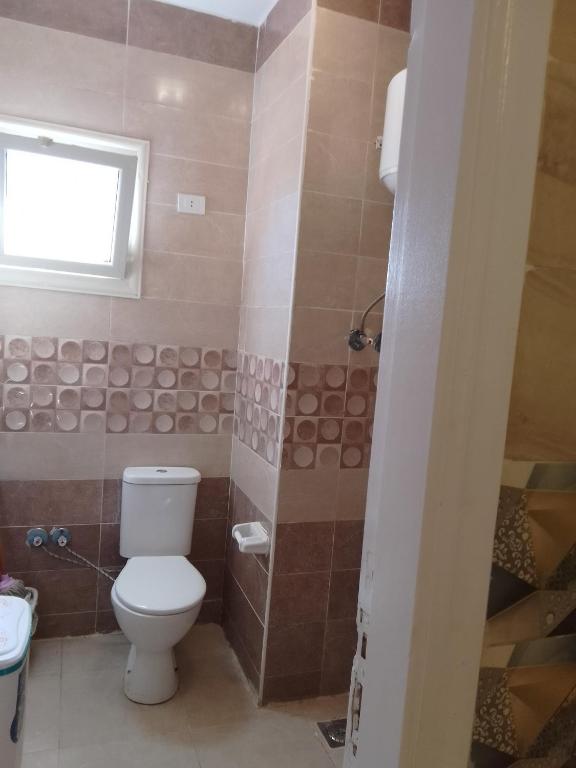 ein Bad mit einem WC und einem Fenster in der Unterkunft مستقبل للشقق الفندقيه والالعاب المائيه in El-Alamein