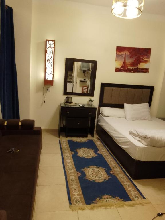 Schlafzimmer mit einem Bett, einem Spiegel und einem Teppich in der Unterkunft مستقبل للشقق الفندقيه والالعاب المائيه in El-Alamein