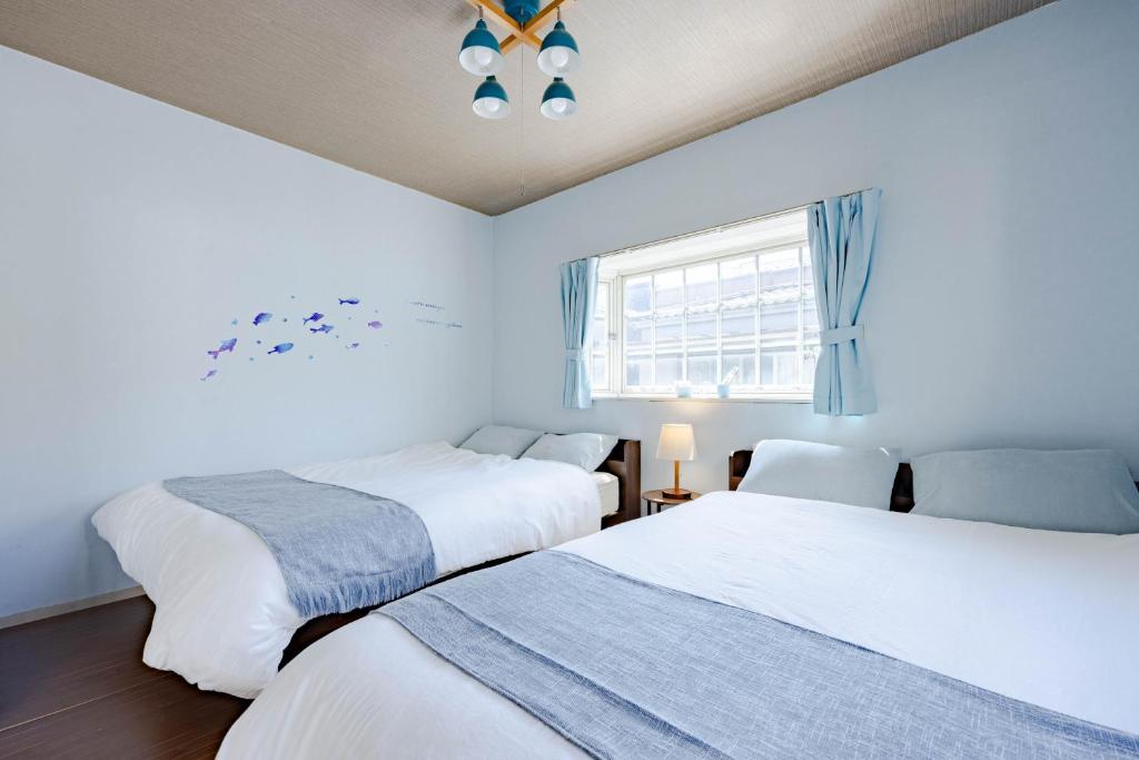 two beds in a room with a window at 1200IN&OUT 10people 75m2 8bed! Exclusive house Shinjuku 13 minutes Shibuya 19 minutesIkebukuro 8 minutes Ueno 9 minutes in Tokyo